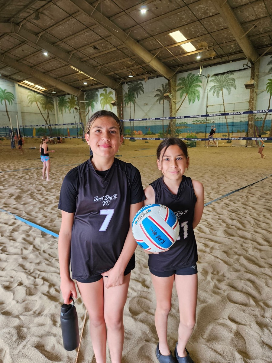 Just Dig It VC players #7 and #21 holding the tournament ball