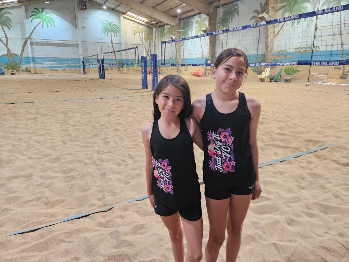 Two Just Dig It VC beach players in club tank tops on the sand